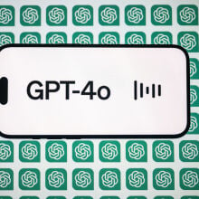  the 'Chat GPT-4o' logo is displayed on a mobile phone screen in front of a computer screen displaying the 'Chat GPT' logo