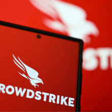 The CrowdStrike logo on phone screen is displayed in front of CrowdStrike logo on laptop screen.