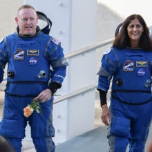 Butch Wilmore and Suni Williams walking in astronaut suits