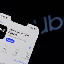 Uber app with the Uber logo in black in the background