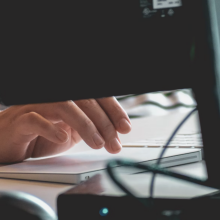 person's hands typing on computer