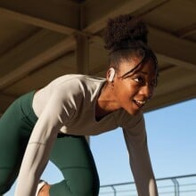 a female runner in the starting spring position wears the jbl endurance peak 3 headphones