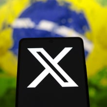 X logo with Brazil flag in the background