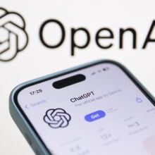 OpenAI logo displayed on a laptop screen and ChatGPT on AppStore displayed on a phone screen