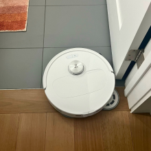 Roborock Qrevo Master robot vacuum cleaning tile and hardwood floor with rug and door in peripherals