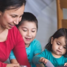 A Native American mom reads to her children.