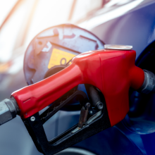 close up of a gas pump filling a blue car 