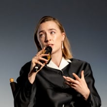 Saoirse ronan on stage, speaking into a microphone