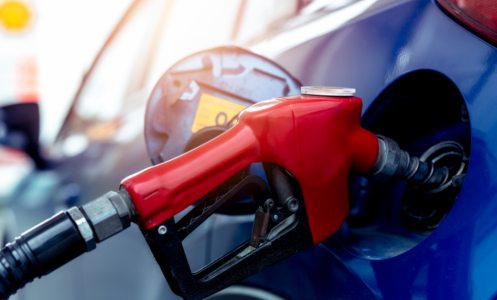 close up of a gas pump filling a blue car 