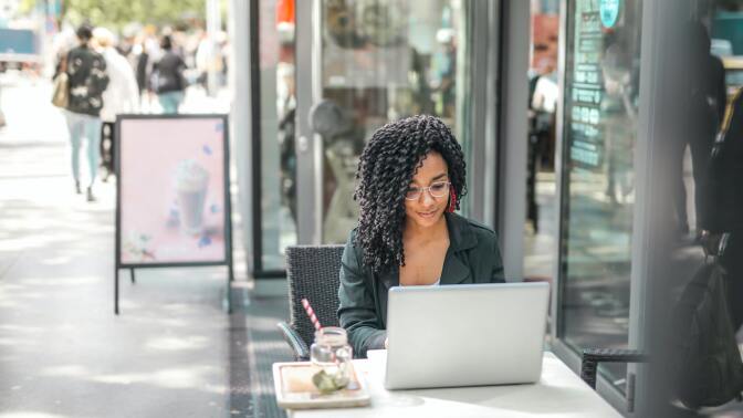 A person taking a course outside on their laptop