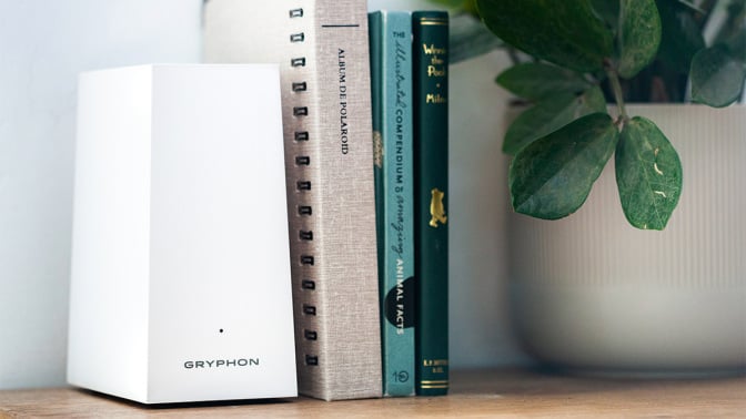 White trapezoidal Gryphon router next to books and plant