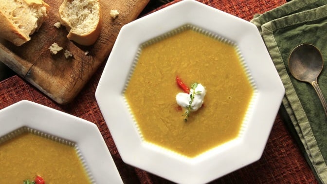 Soup and bread on a table.