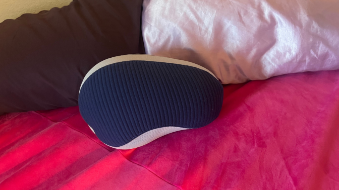 bean shaped pillow on pink bedspread