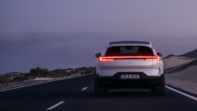 Polestar SUV driving on road beside body of water