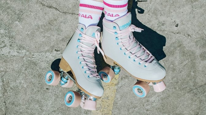 impala retro roller skates on pavement with tube socks that read 'impala skate'