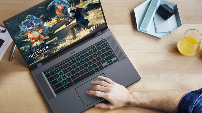 a top-down view of a man playing "the witcher 3" on a Acer Chromebook 516 GE at a wooden desk