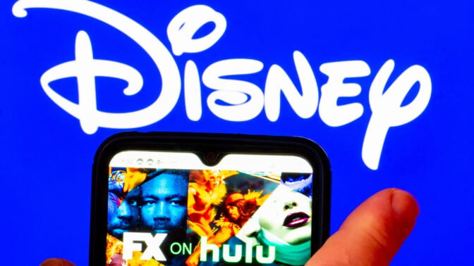 The FX on Hulu logo is displayed on a smartphone screen, with a Disney logo in the background.