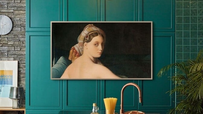 a samsung the frame TV sits on a turquoise wall in a kitchen with still frame art work displayed