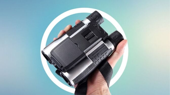 hand holding binoculars over blue background