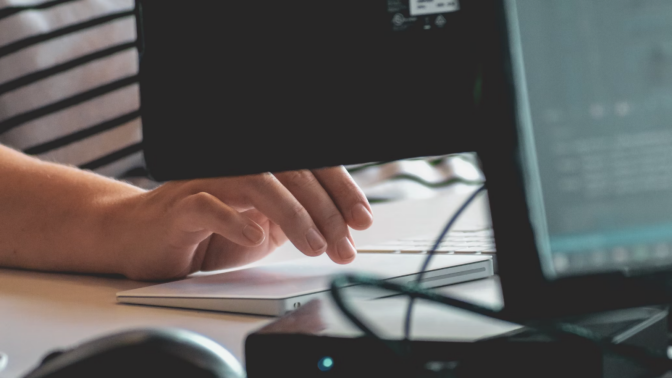 person's hands typing on computer