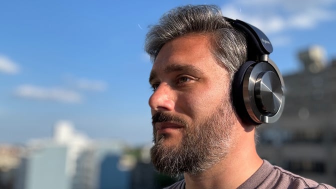 man wearing the dyson ontrac headphones against blue sky