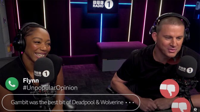 A man and a woman sit in a radio studio, wearing headphones and laughing.