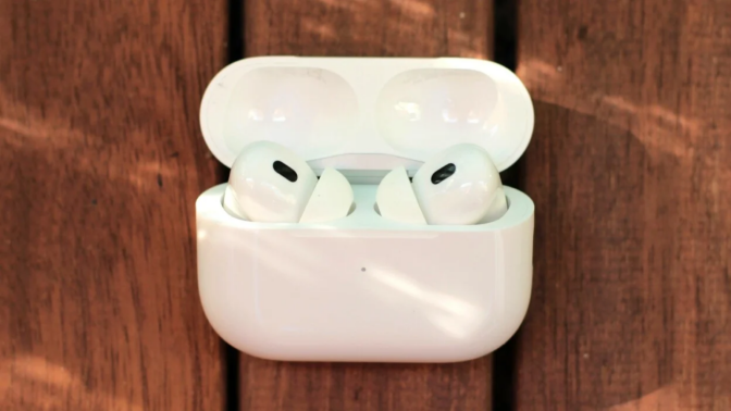 the second generation apple airpods pro in their charging case on a wooden surface