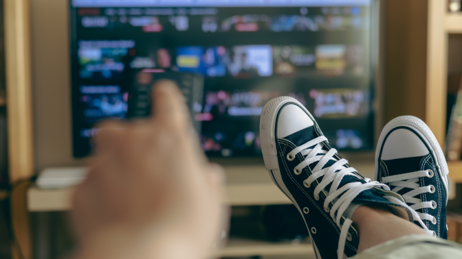 person holding remote up to tv