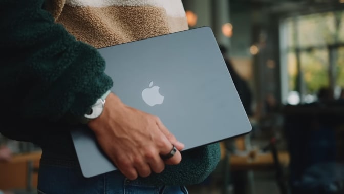 Man holding a MacBook Pro