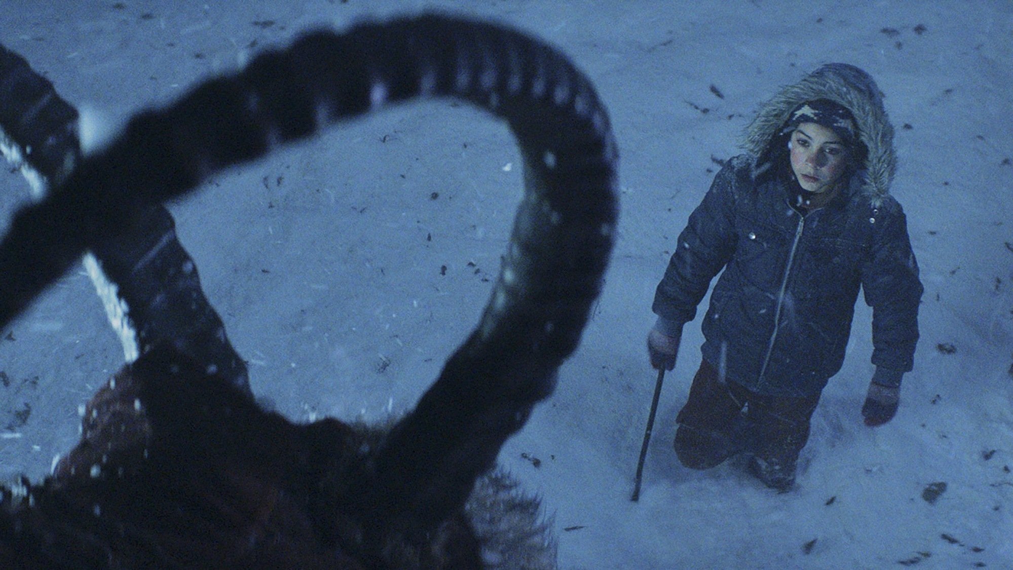 A boy (Emjay Anthony) stands before a towering monster in "Krampus."