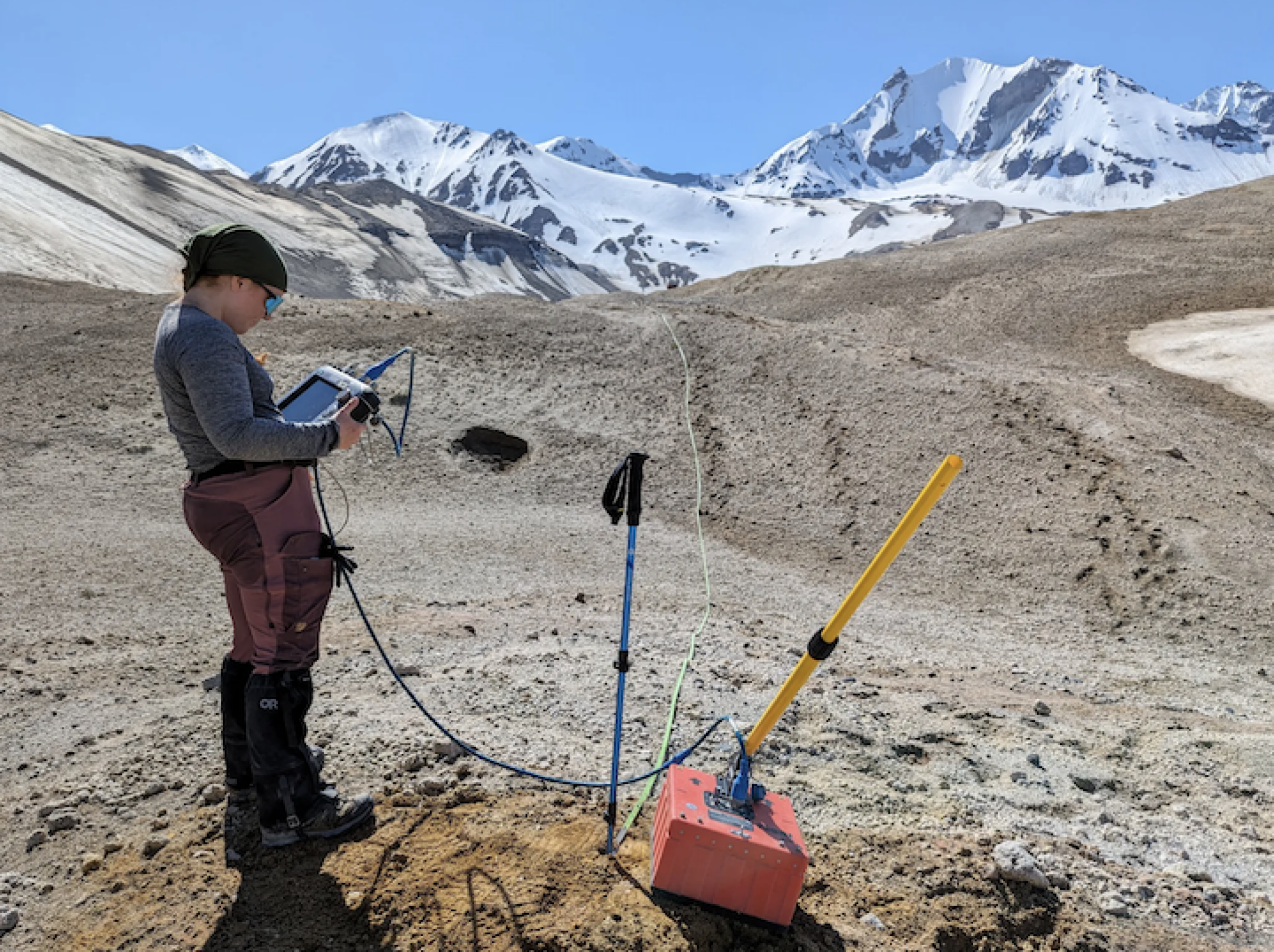 Scientist Emileigh Shoemaker uses a ground-penetrating radar to investigate a glacier preserved beneath a thick layer of volcanic ash.