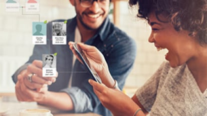 Two people holding an AncestryDNA kit.