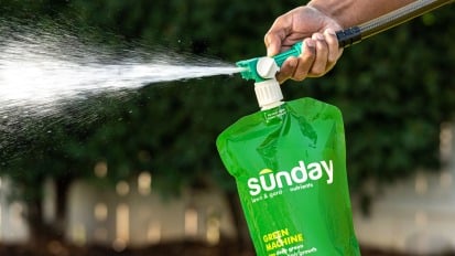 a sunday lawn care bag attached to a hose spraying water